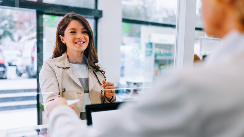 Woman purchasing at pharmacy