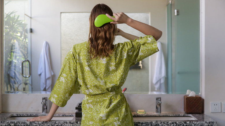 Woman using detangling brush