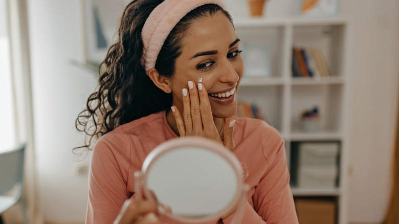 Woman moisturizing her skin