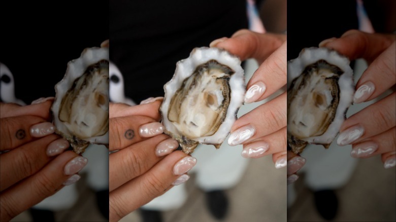 woman holding oyster with oyster manicure