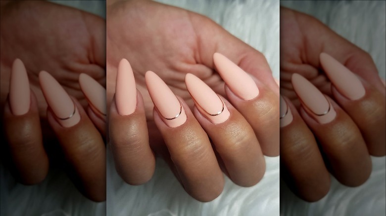 Woman with peach and gold nails