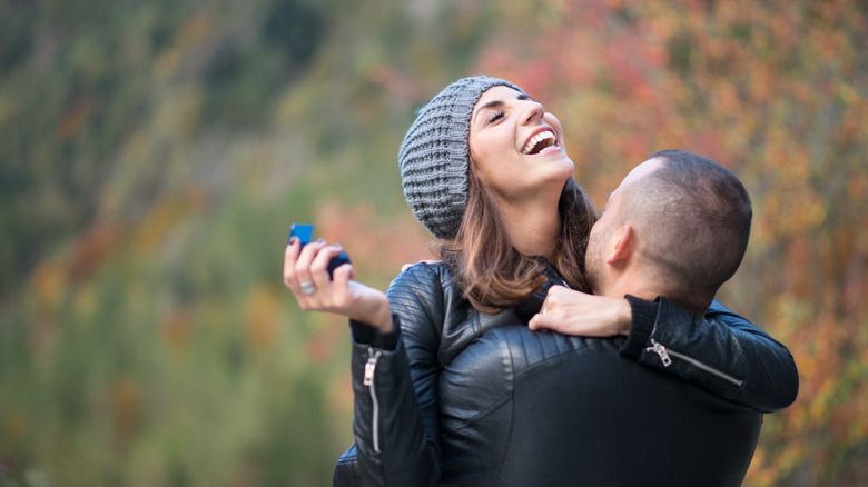 Engaged couple laughing and hugging