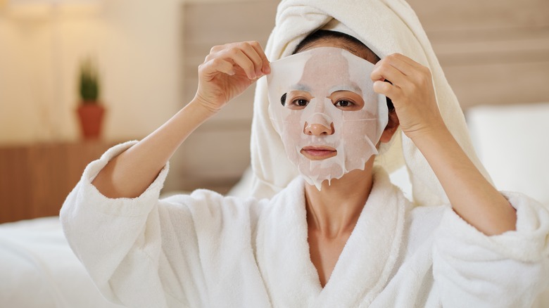 Woman peeling off mask