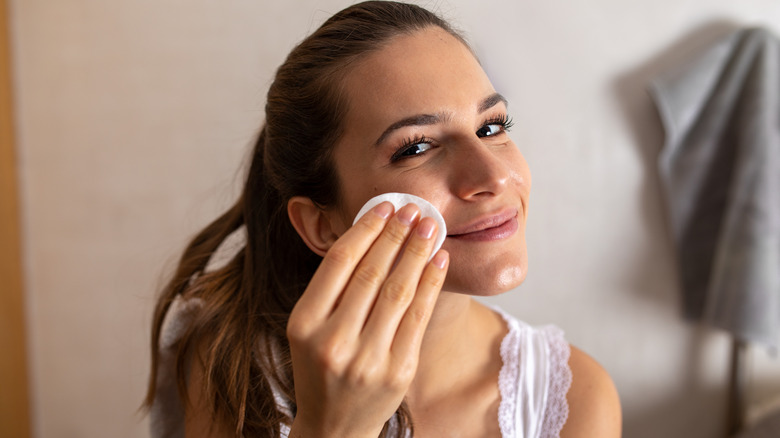 Woman cleansing face