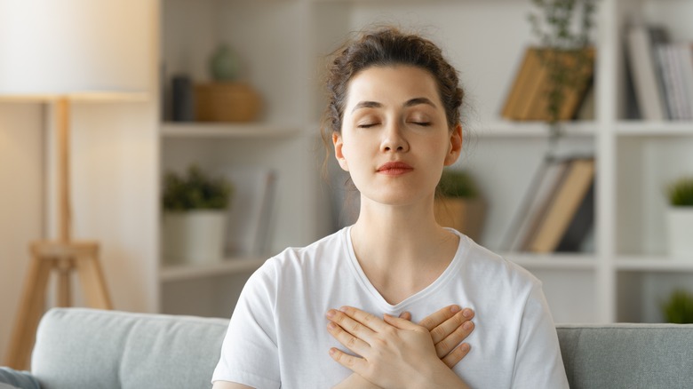 Woman meditating in living room 