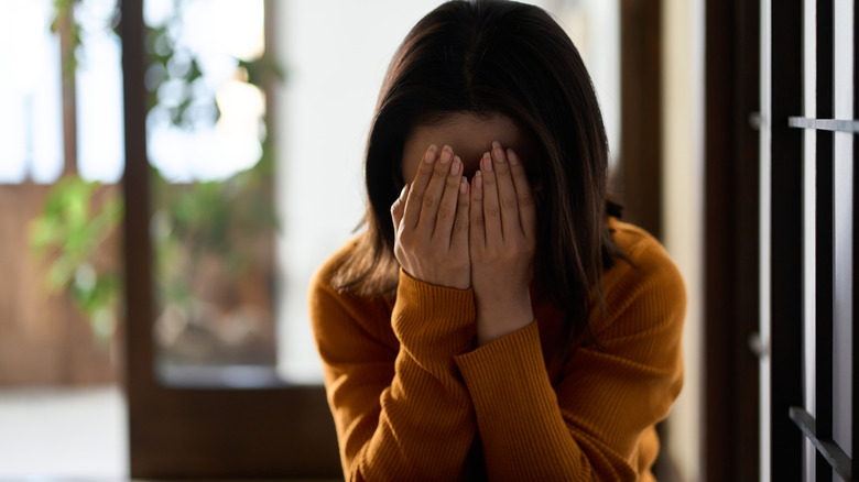 woman covering their face