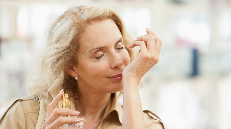 Woman smelling perfume on wrist