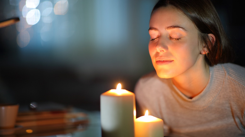 relaxed woman smelling candles