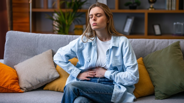 Woman clutching her abdomen 