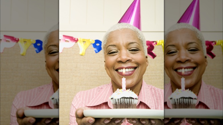 Woman holds birthday cupcake