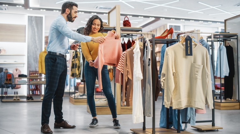 Shopping woman is helped by employee