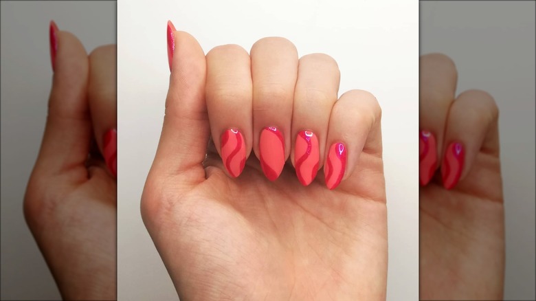 hand with peach pink swirl nails