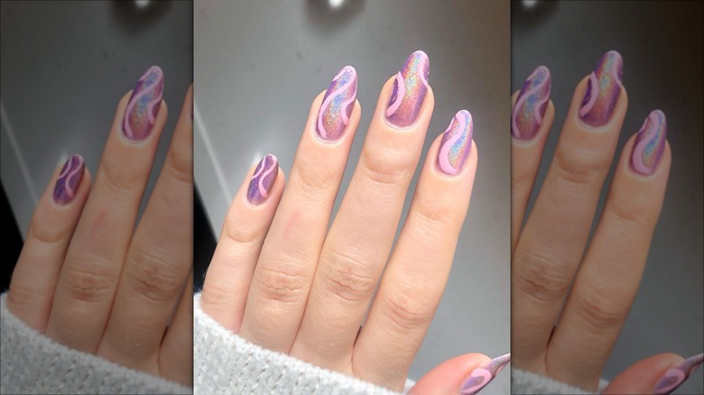 hand with pink swirl chrome nails