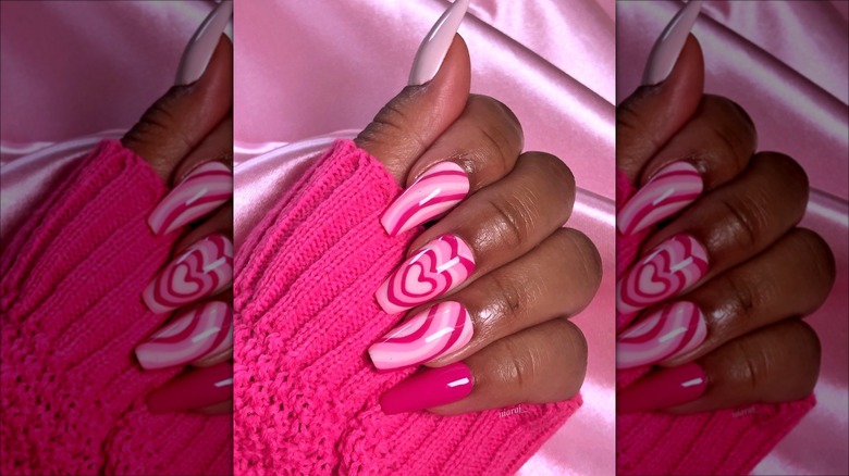 hand with pink swirl heart nails