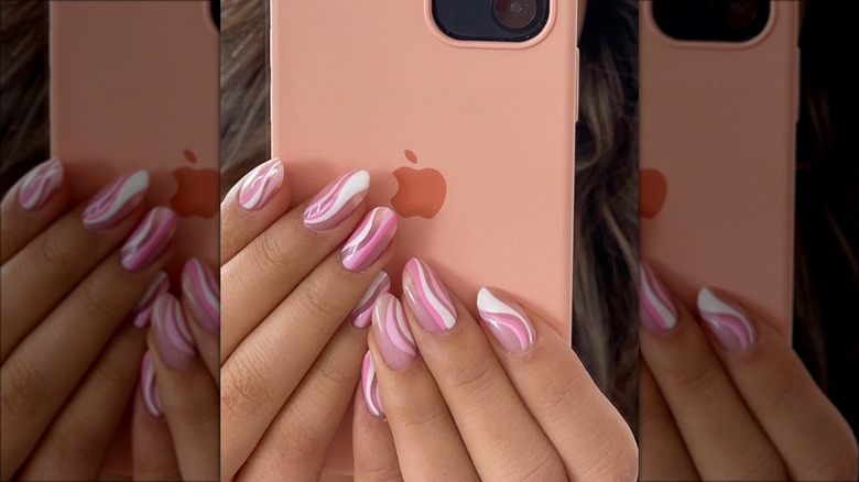 hand with white pink swirl nails