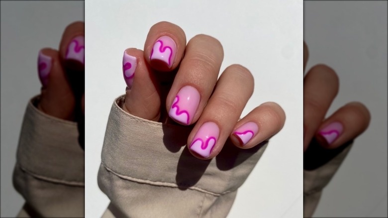 hand with pink swirl drip nails