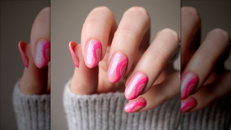 hand with sparkly pink swirl nails