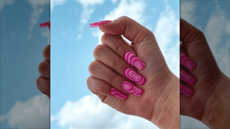 hand with warped smiley pink swirl nails