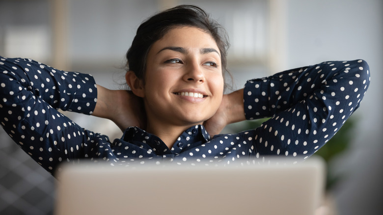 Woman daydreaming at computer