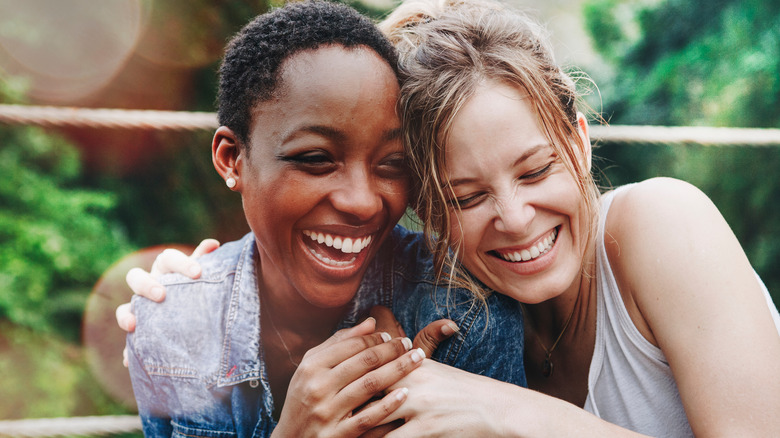 Two women laughing and hugging