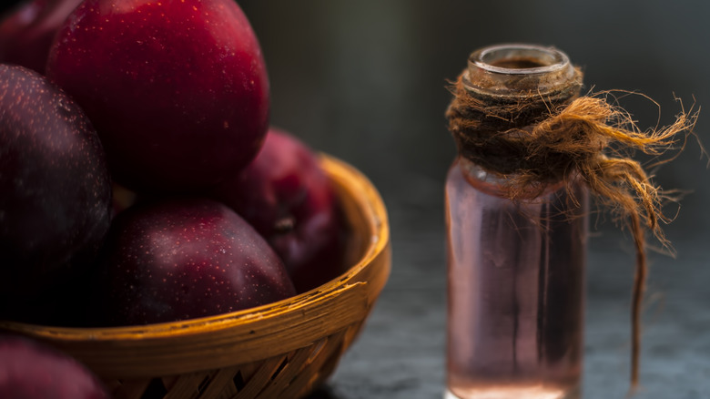 Basket of plums and oil vial
