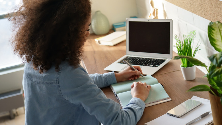 Person writing at desk