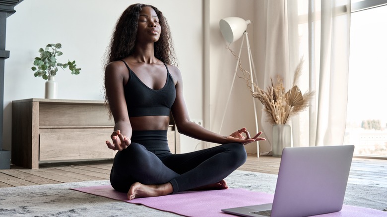 Woman practicing meditation at home