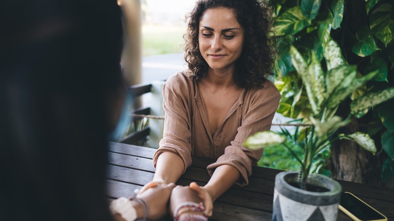 Two people holding hands across table 