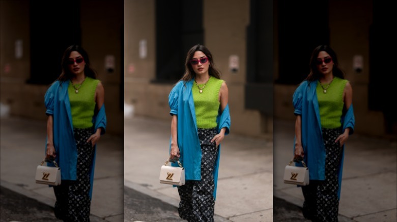 woman wearing a green top, blue poplin shirt, and printed pants