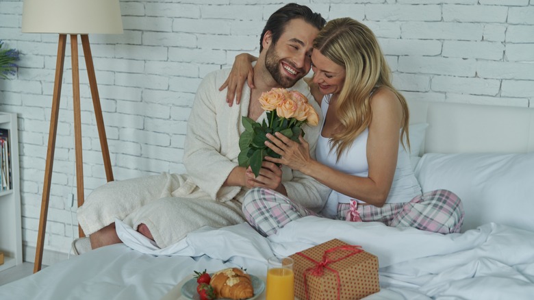 Man giving women breakfast in bed