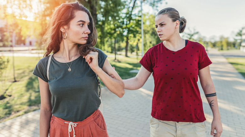 unhappy person grabbing partner's arm 