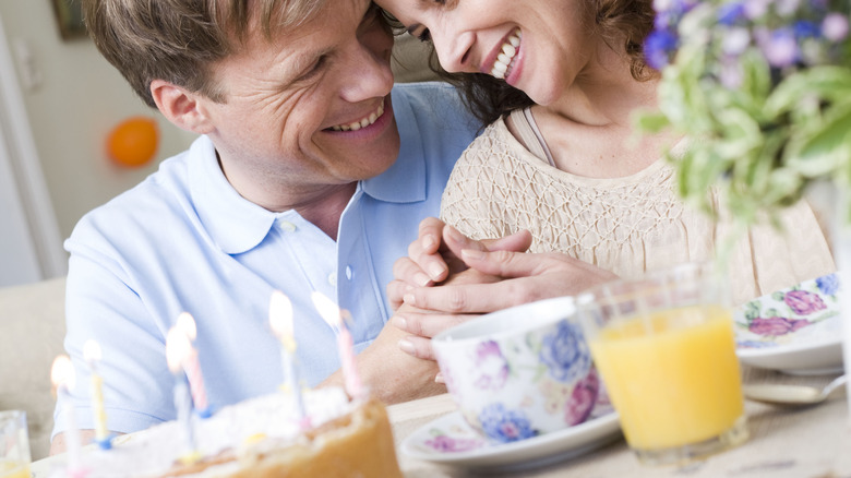 Woman and man smiling holding hands 