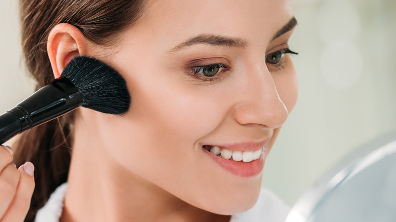 woman applying bronzer