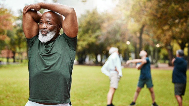 Man stretching arm outside