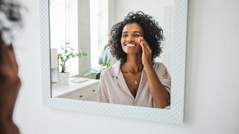 Woman appreciating skin in mirror