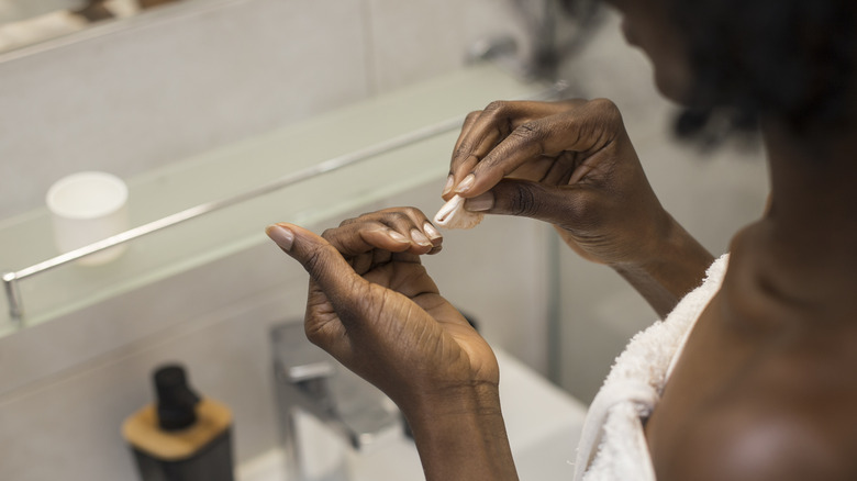 A woman cleaning her nails