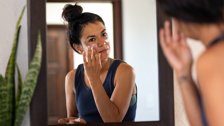 woman applying lotion to face