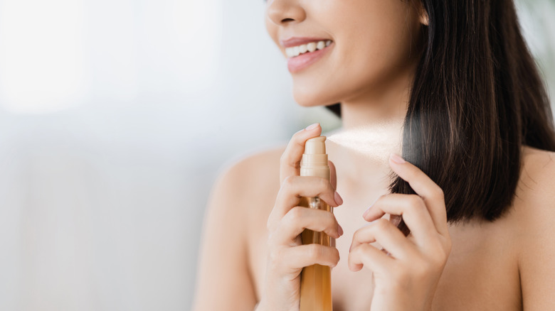 woman applying to spray to ends of hair