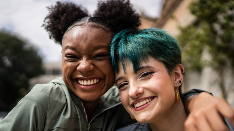 Two smiling, hugging friends