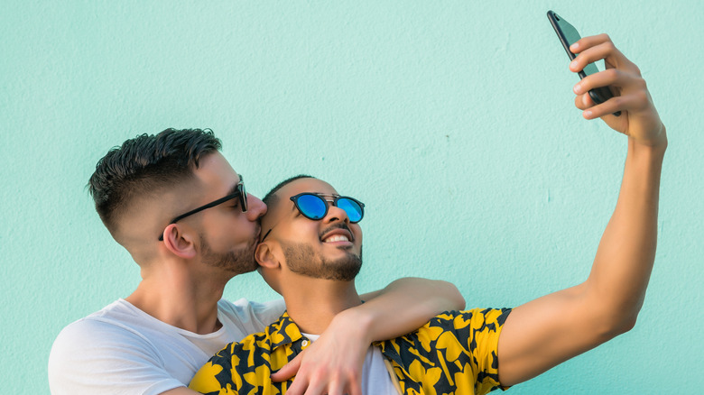 Two men embracing and taking selfie