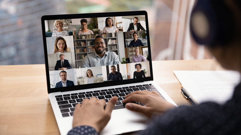 Person viewing laptop with video conference meeting