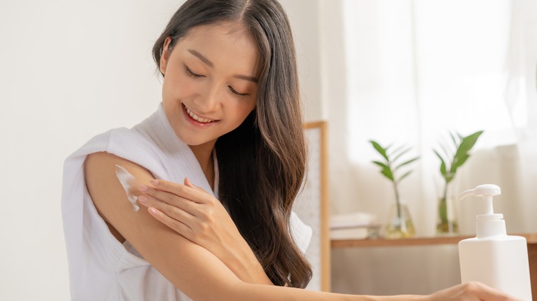 woman using glycerin moisturizer on arm