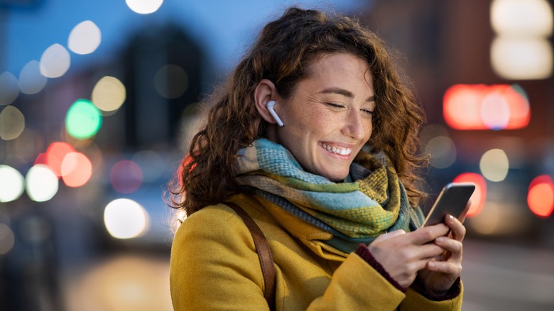 Woman smiling while checking her phone