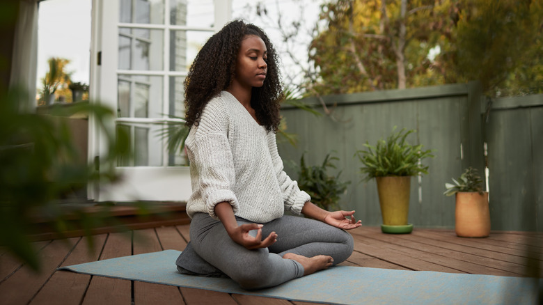 Woman practicing yoga outdoors on mat