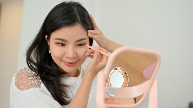 Woman applying winged eyeliner