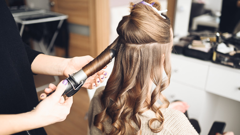 hairdresser curling woman's hair