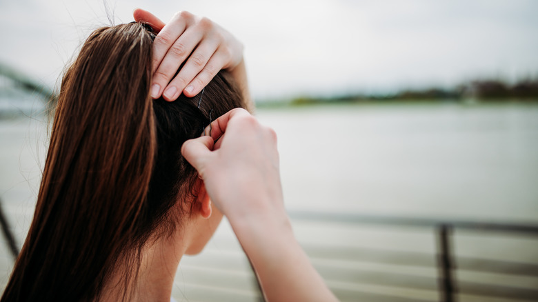 woman adding bobby pins to ponytail