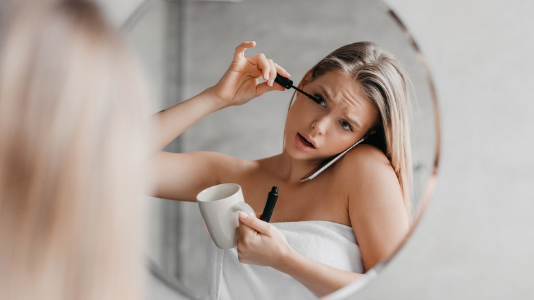 woman putting on mascara 