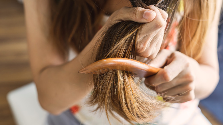 Woman brushing tangled hair