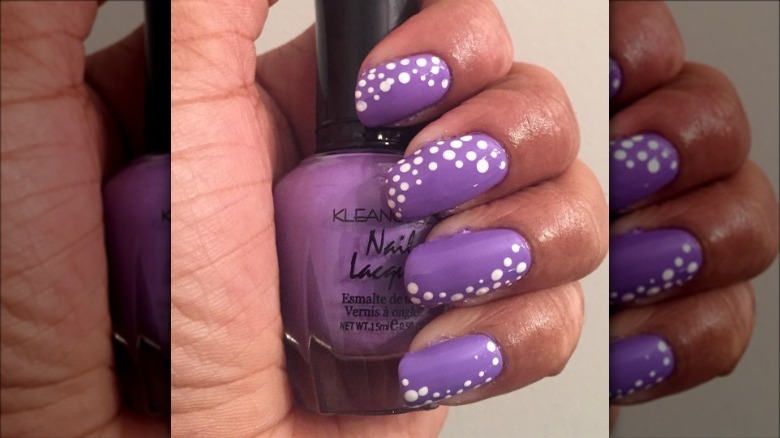 woman's hand purple polka dot manicure